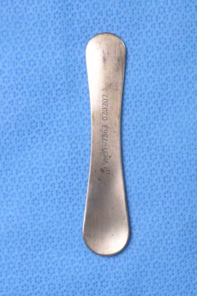 This large instrument has a concave and a convex surface which serve to complement the contour of the globe and allow for its placement between the lid and the globe during eyelid surgery. It provides a rigid surface on which lid dissection can be safely performed while protecting the globe.  This plate is commonly used for this purpose when harvesting a Hughes flap.  It resembles a shoehorn and for this reason is also commonly called a "shoehorn retractor". 