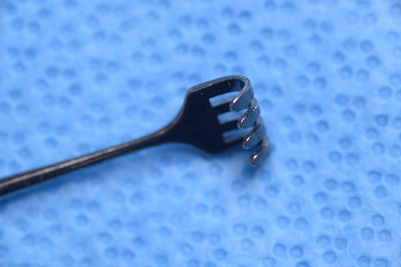 This retractor resembles a small rake with its four wide, blunt prongs. It is helpful in tight spaces such as the medial canthus/lacrimal sac. Examples of its use include when removing the medial fat pad during blepharoplasty and when performing transcaruncular dissection. 