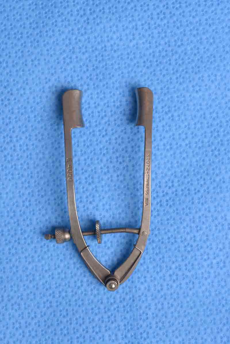 This is a rigid speculum which allows for adjusting of the width of the palpebral fissure. In addition, it has guards to keep the eyelashes away during surgery although this can also be accomplished with the use of surgical drapes. A possible disadvantage of this speculum is that it can create significant force on the eyelids which may increase the rate of post-operative ptosis or other eyelid malpositions.